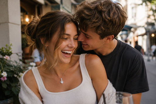 a young boyfriend and girlfriend embrace at an outdoor mall restaurant wearing a necklace from Bae and Friends