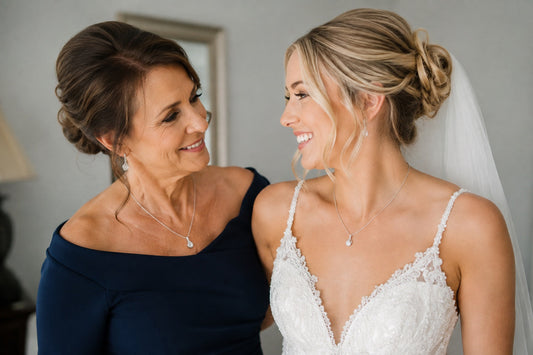 A beautiful bride standing with her mother in law smiling before a wedding
